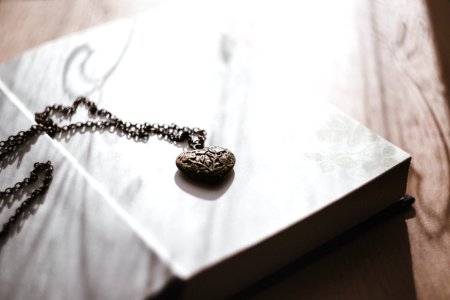 A heart necklace on an open book photo