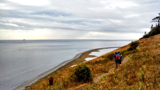 Hikers watch a distant lightning storm from the bluffs of Whidbey Island