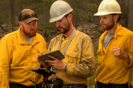 DIVS Tony Harding consulting Avenza on a tablet, giving direction to Warm Springs Hotshots at DP 43