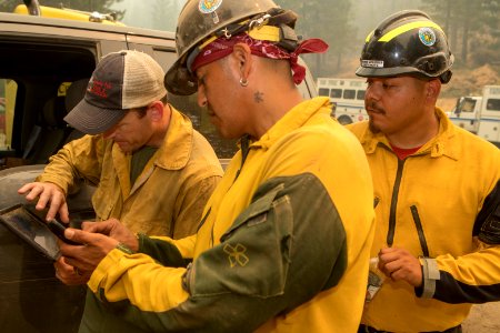 DIVS Tony Harding consulting Avenza on a tablet, giving direction to Warm Springs Hotshots at DP 43