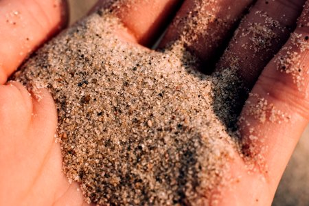 Sea beach sand in a hand closeup photo