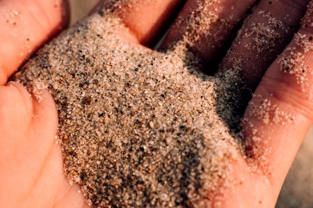 Sea beach sand in a hand closeup