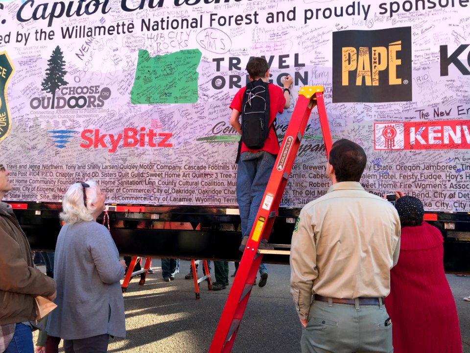 FS employee helping kids sign banner