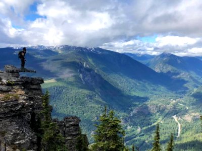 TrailCrewpersonLookingOverValley-OkaWenNFbyMasonSchuurUSFS-June2019