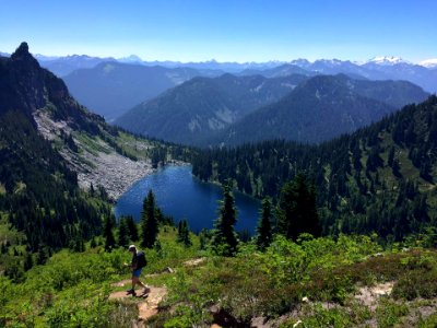 Hiker-WalkingAboveSmallLake-OkaWenNFbyMasonSchuurUSFS-Aug7-2018