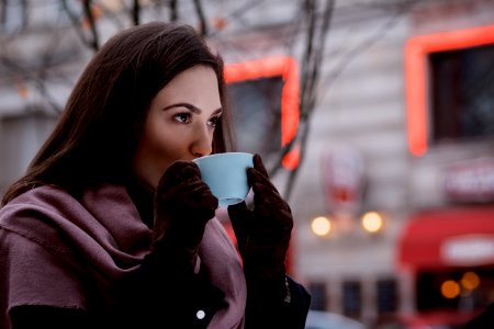 A woman drinking coffee outdoors photo