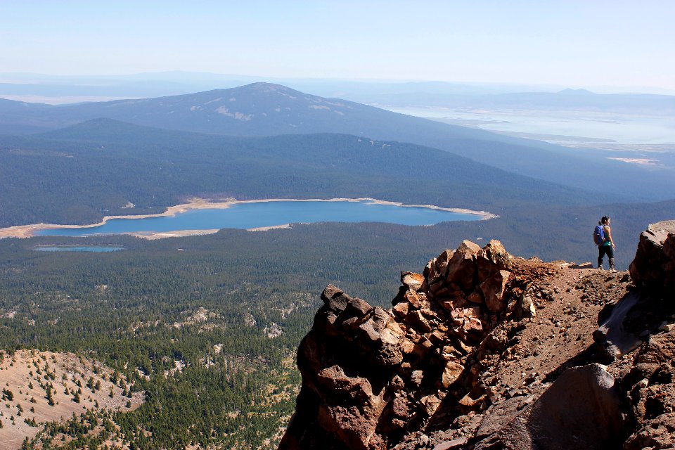 Hiker near the summit of Mount McLoughlin, with Fourmile Lake and Pelican Butte in the background, Sky Lakes Wilderness on the Rogue River-Siskiyou National Forest