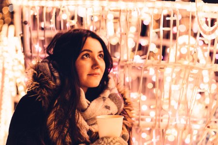 Christmas lights and girl holding coffee photo