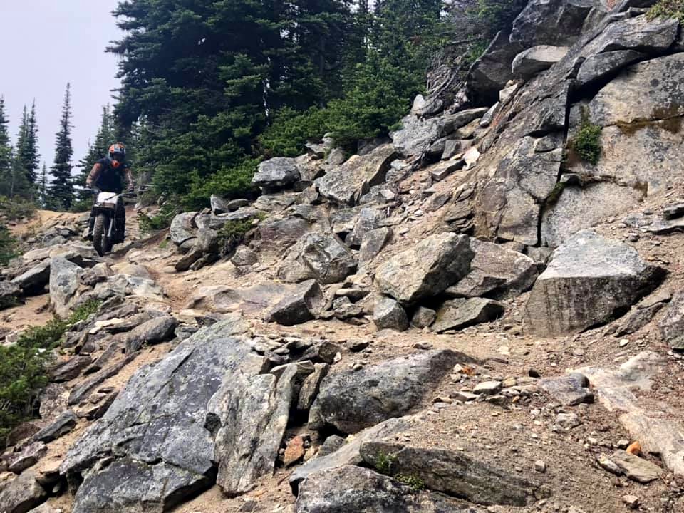 TrailCrewpersonOnMotorcycleOnTrail-OkaWenNFbyMasonSchuurUSFSJune2019