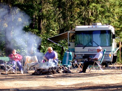 Camping-ThreePeopleInChairsAndAdjacentRV