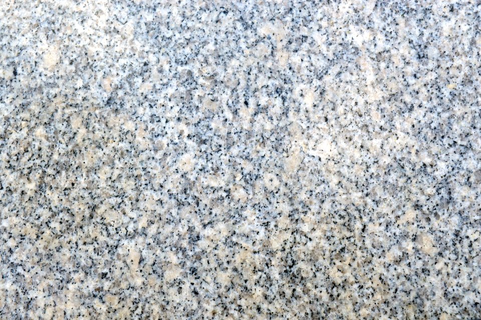 Texture of beige and grey natural granite with polished surface photo