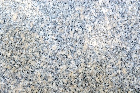 Texture of beige and grey natural granite with polished surface