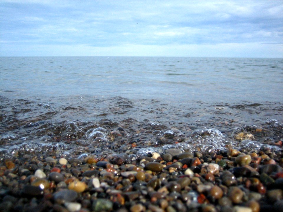 Pebbles, bubbles, water and sky.