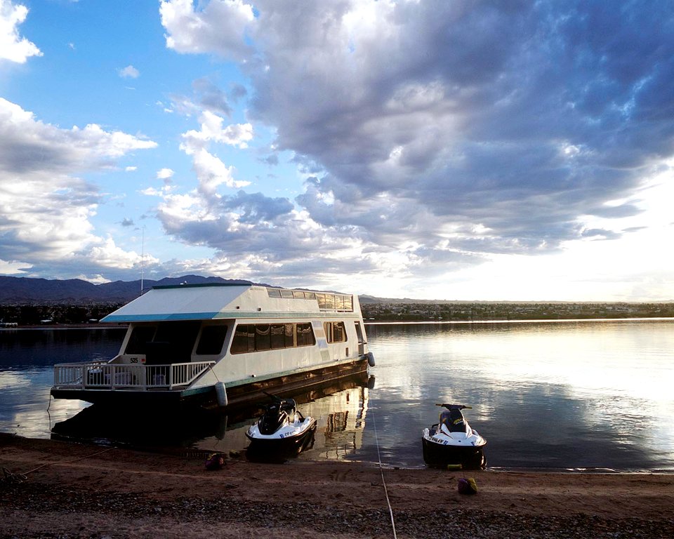 A houseboat on the shore at sunrise on Lake Havasu.