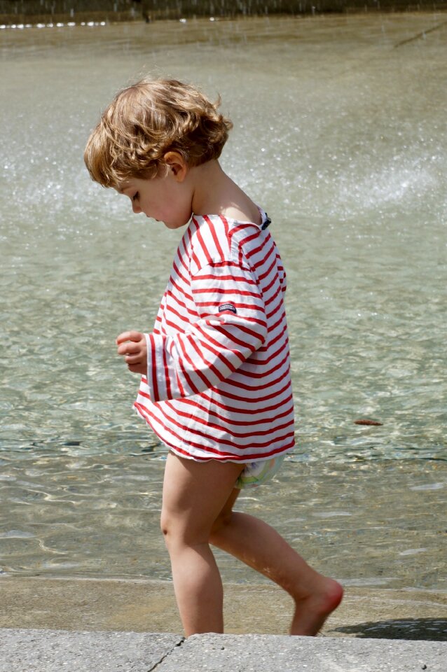 Small child barefoot paddling