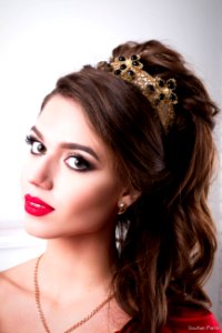 Elegant woman with chic make-up and hairdo with a crown on his head