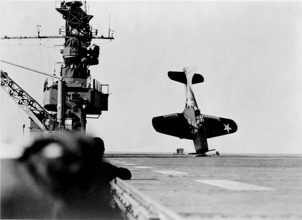Douglas SBD Dauntless dive bomber balanced on nose after crash landing on carrier flight deck, June 21, 1943