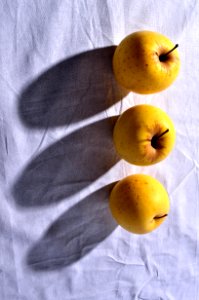 Trois pommes sur la nappe