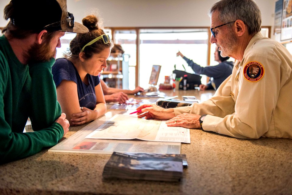 Volunteer helping visitors at Oasis Visitor Center