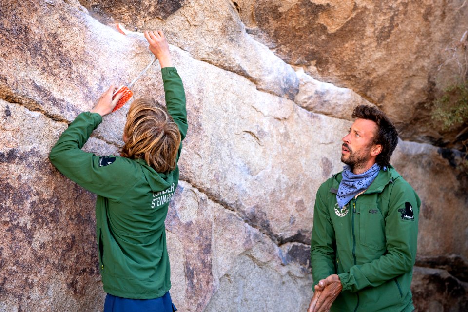 Climber stewards cleaning chalk marks off of Gunsmoke