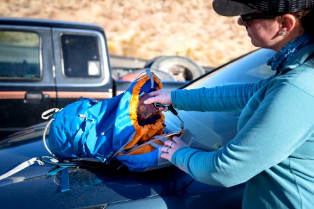 Woman packing backpack before a hike photo