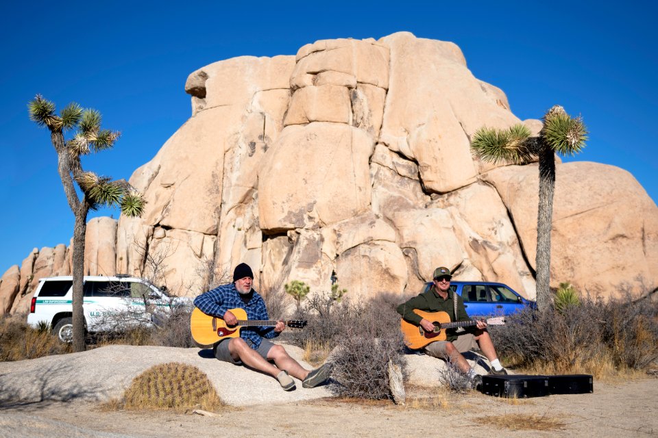 Two guitar players in front of Intersection Rock