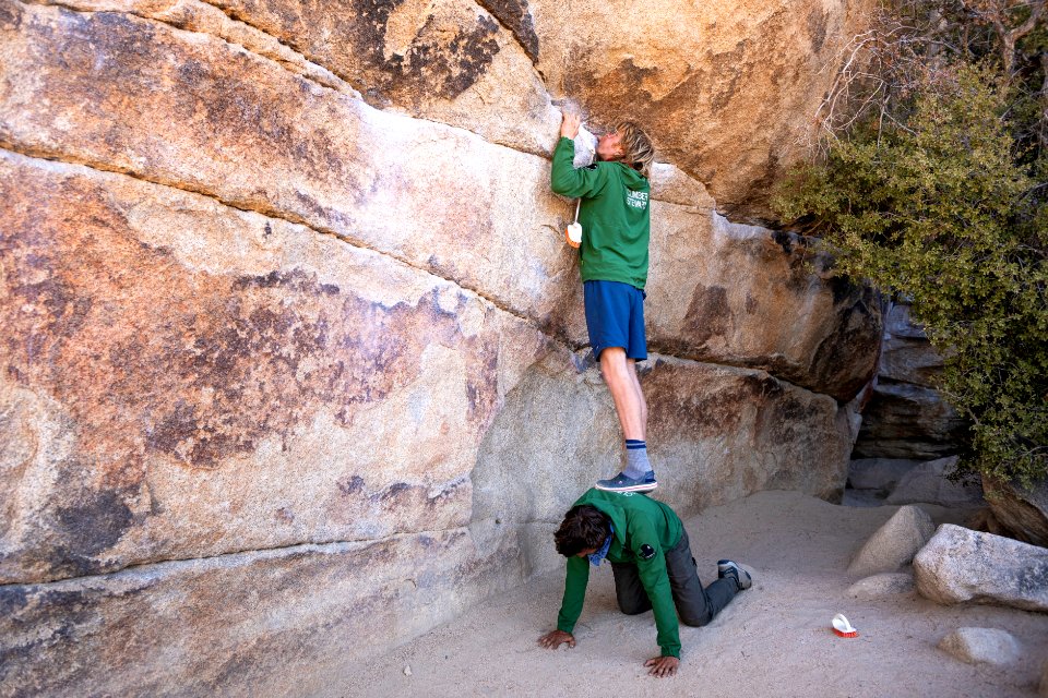 Climber stewards cleaning chalk marks off of Gunsmoke