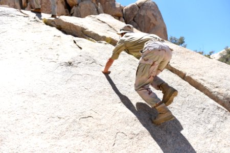 Hiker scrambling up a boulder photo