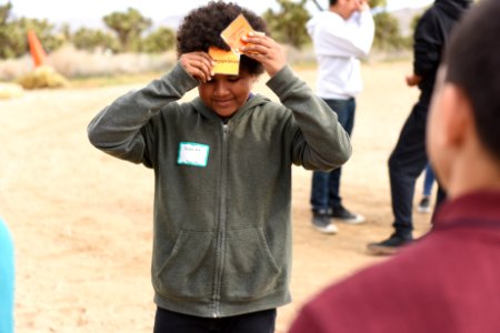 Student holds up card that reads "overpopulation" photo