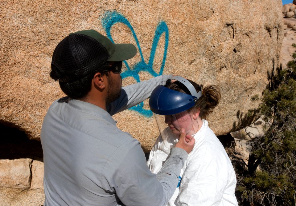 Ranger helping a volunteer with safety equipment.