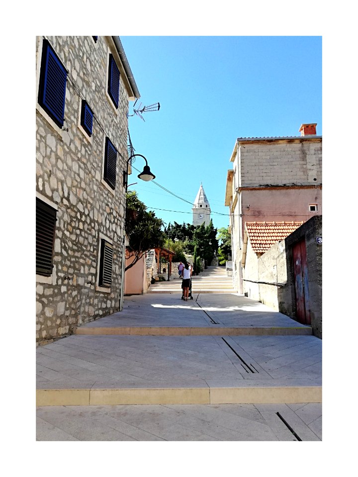 Église en vue. Rue pavée et escaliers