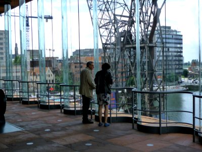 2012.08 - 'Visitors of the MAS museum in Antwerp', looking in the direction of the cathedral through the large ribbed glass walls of the MAS-building - Museum aan de Stroom- photography of modern architecture in the urban city - Fons Heijnsbroek, Belgium