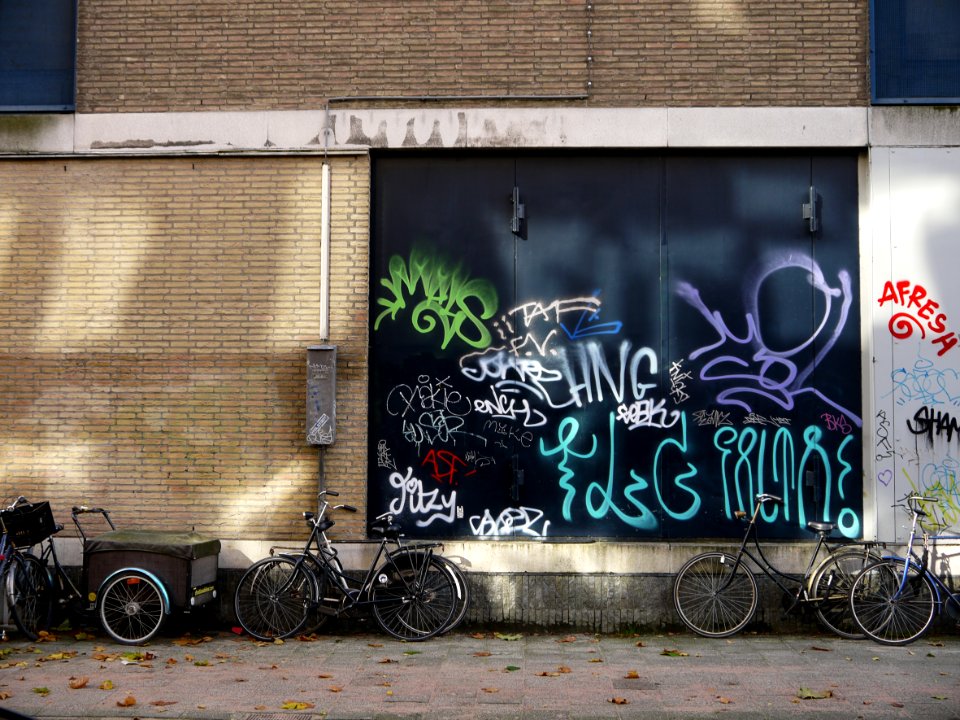 Urban collage: brick wall with a collection street graffiti tags on a nice dark-green background-wall in sunlight and shadow on Hoogtekadijk; photo Amsterdam city; urban photographer Fons Heijnsbroek, 2013