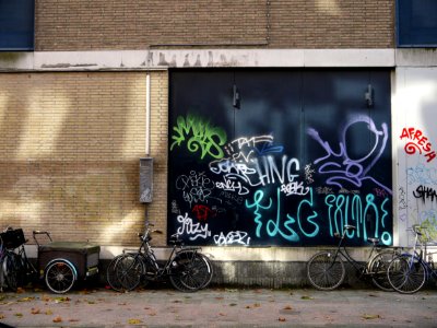 Urban collage: brick wall with a collection street graffiti tags on a nice dark-green background-wall in sunlight and shadow on Hoogtekadijk; photo Amsterdam city; urban photographer Fons Heijnsbroek, 2013 photo