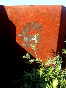 2016.09 - Street-art photo of a 'Mysterious head' on a rusty pile sheeting element, at the North-border of the IJ water, Amsterdam - geotagged free urban photo, in public Commons domain; Dutch photography, Fons Heijnsbroek, The Netherlands