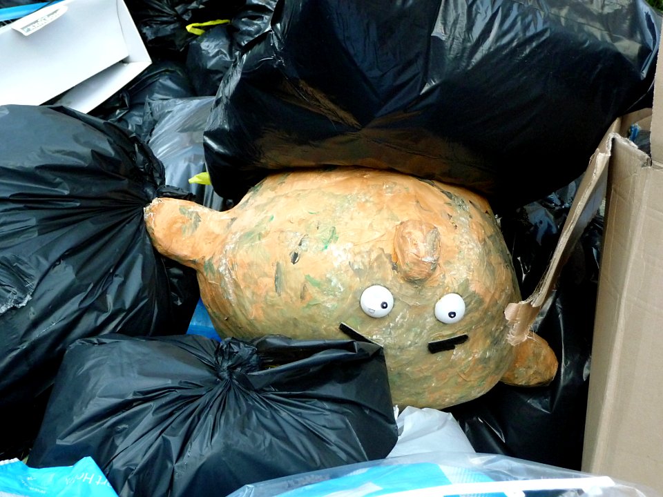 2016.03 - Amsterdam photo of urban street-art made by accident from garbage: a puppet-face in the dump in the city-street; geotagged free urban picture, in public domain / Commons; Dutch photography, Fons Heijnsbroek, The Netherlands photo