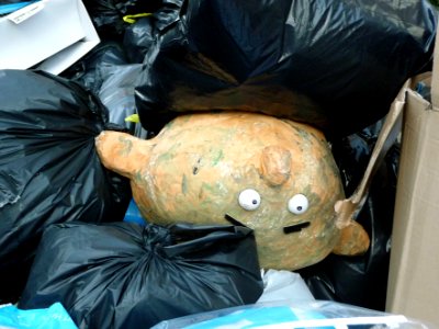 2016.03 - Amsterdam photo of urban street-art made by accident from garbage: a puppet-face in the dump in the city-street; geotagged free urban picture, in public domain / Commons; Dutch photography, Fons Heijnsbroek, The Netherlands