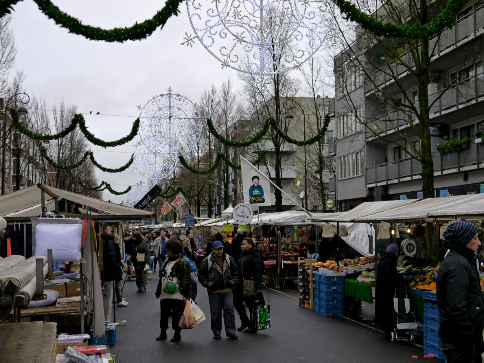 Photo of the Dappermarkt (daily marketplace) in district Amsterdam Oost (East) and shopping people - on a gray day in December with Christmas lights in the streets; Amsterdam city; - urban photography by Fons Heijnsbroek, the Netherlands, 2013