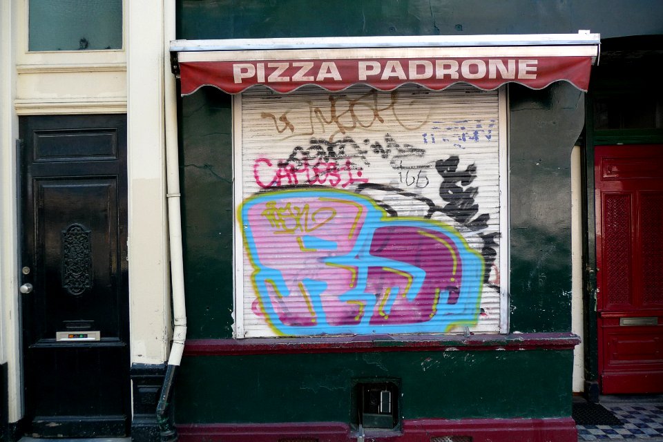 2011.04 - 'Graffiti at the facade of a small pizza-shop', under 19th century living-houses in Amsterdam city, Spring; geotag free urban picture, in public domain / Commons CCO;  city photography by Fons Heijnsbroek, The Netherlands