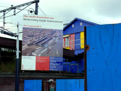 2006.10 - 'Billboard: re-building the Central Station area' - Amsterdam photos & pictures, location along the train track together with construction chains;  east-side of the stationr; Dutch city + geotag, Fons Heijnsbroek, The Netherlands
