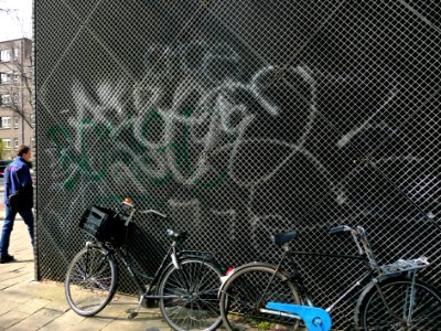 2015.04 - Amsterdam photo of textures of walls - graffiti tags, sprayed on a metallic grid in the fresh sun-light of early Spring; a geotagged free urban picture, in public domain / Commons CCO; city photography by Fons Heijnsbroek, The Netherlands photo