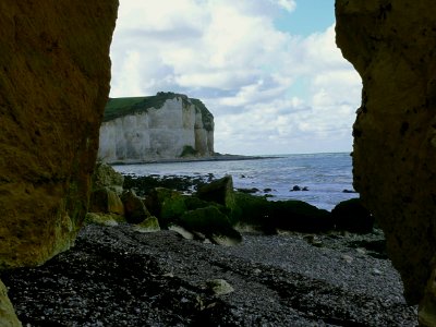 2007.09 - 'A see-through view between two ocher-colored rocks', on the steep cliffs on the shore of Petit-Dalle in Normandy France under a blue-white sky; French landscape photography, Fons Heijnsbroek photo