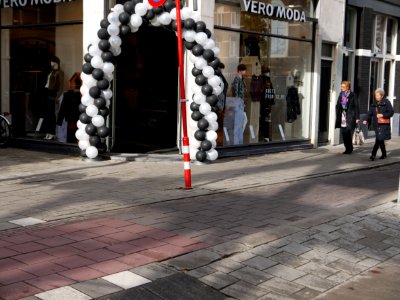 Street life with clothing shop entrance and shopping women in the Ferdinand Bolstreet in sunlight and shadows and shop-entrance; photo Amsterdam city; urban photographer Fons Heijnsbroek, 2013 photo