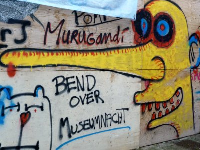 Urban street-art graffiti - a collage on a wooden construction-wall on Plantage Muidergracht: a painted long-nose-face and a cat; photo Amsterdam city; urban photographer Fons Heijnsbroek, 2013