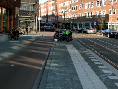 2013.04 - 'A view through the sunny Sunday-street Witte de Withstraat', with a characteristic urban row of social housing blocks in Amsterdam school style architecture; city Amsterdam; urban photography, Fons Heijnsbroek photo