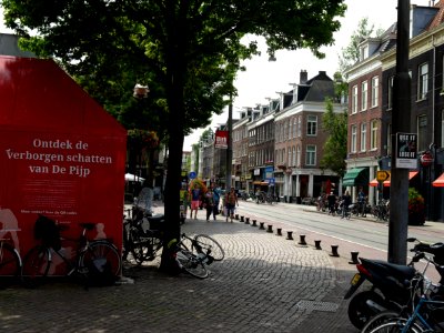 View on the Ferdinand Bolstraat and its many trees - with a red-colored building-barn for metro-constructions; city center of Amsterdam; - urban photography by Fons Heijnsbroek, the Netherlands, 2013