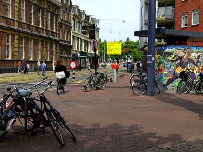 View on the beginning of the Ferdinand Bolstraat and a part of the Heineken-plein (square) to the right - with colored mosaic wall art made by artist Fabrice; city center of Amsterdam; - urban photography by Fons Heijnsbroek, the Netherlands, 2013