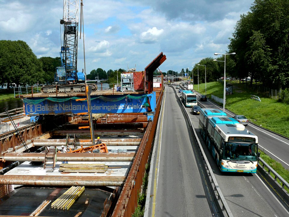 2007.08 - 'View over the motorway leaving Amsterdam' northwards and to the left the metro construction site underground with the rolling work platform and building crane; Dutch city photo + geotag, Fons Heijnsbroek, The Netherlands