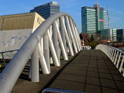 View on the metal tubings of the modern foot bridge connecting Oosterdokskade with Dijksgracht and the pedestrian route to the Passengers Terminal and Music House IJ, Amsterdam city; - urban photography by Fons Heijnsbroek, the Netherlands, 2013 photo