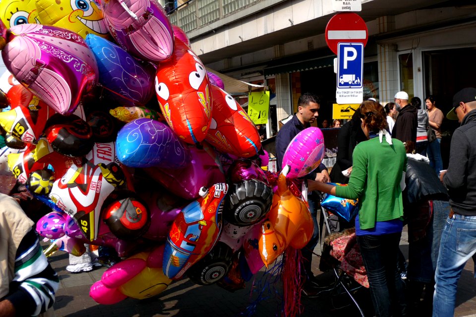 2011.04 - 'Young woman selling balloons at the street-fair', photo in the Kinkerstraat in the light of Spring; Amsterdam city, district Oud-West - urban photography in the Netherlands, Fons Heijnsbroek
